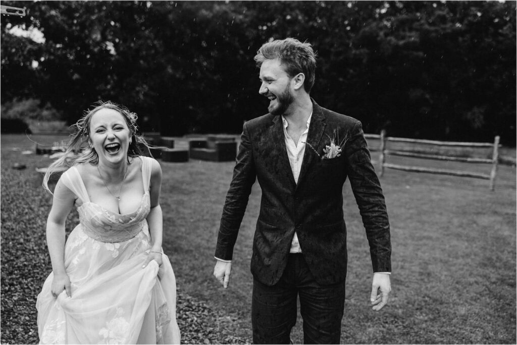 Bride and Groom laughing in the rain
